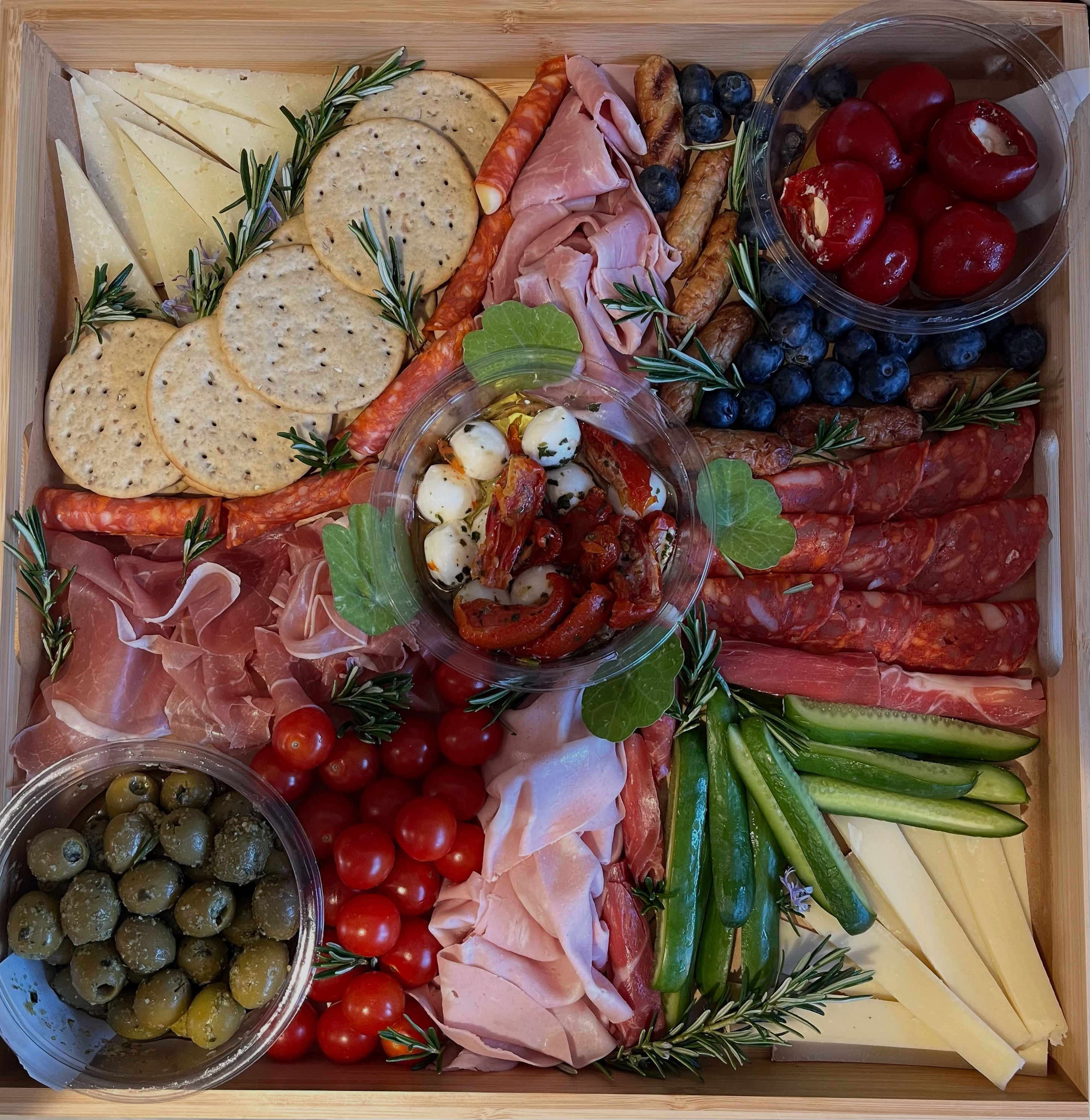 Charcuterie box with cheeses, cured meats, olives and fresh vegetables