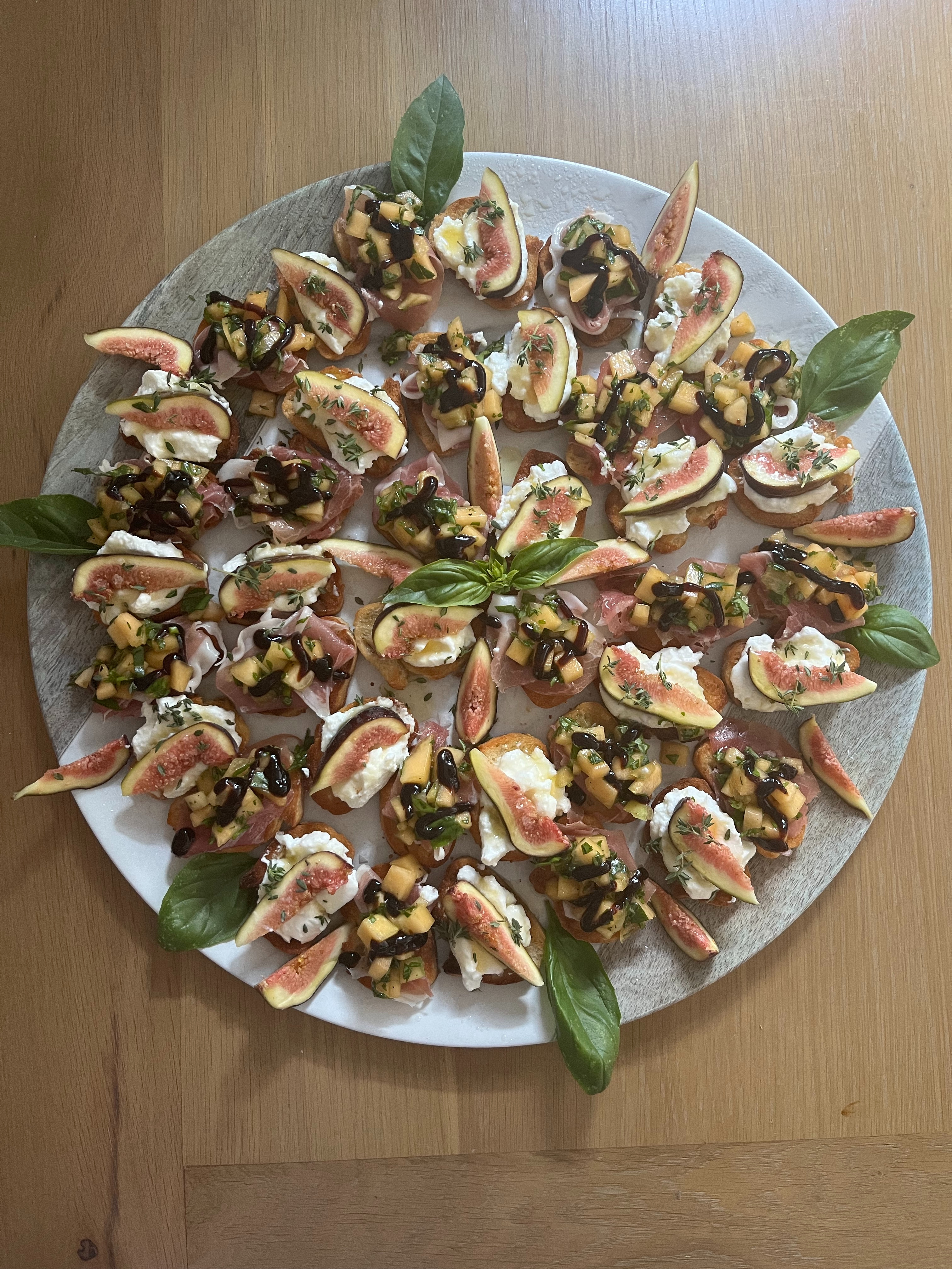 Fig, soft cheese and prosciutto canapes with fresh basil