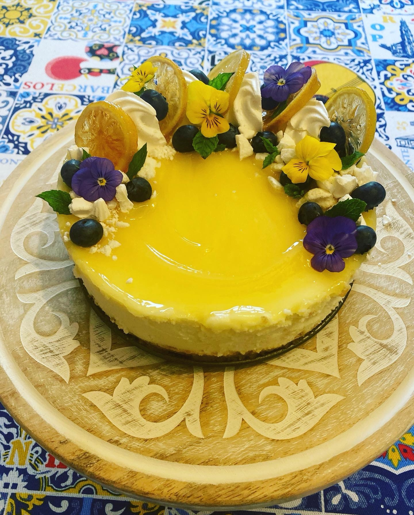 Lemon cake decorated with blueberries, edible flowers and candied lemon